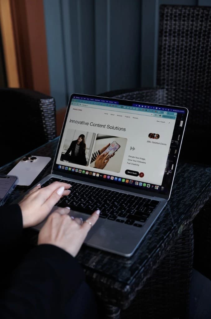 Laptop displaying Image Logix website — Innovative Content Solutions hero and studio layout preview