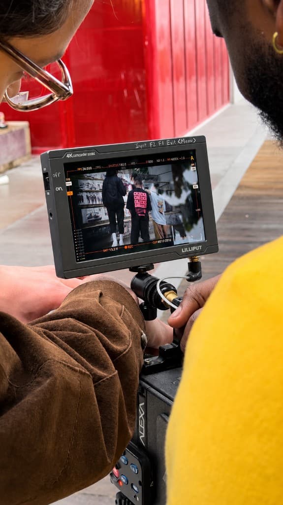 Image Logix crew reviewing a take on a professional cinema monitor on location — real teams, campaigns, and client work for Vancouver businesses
